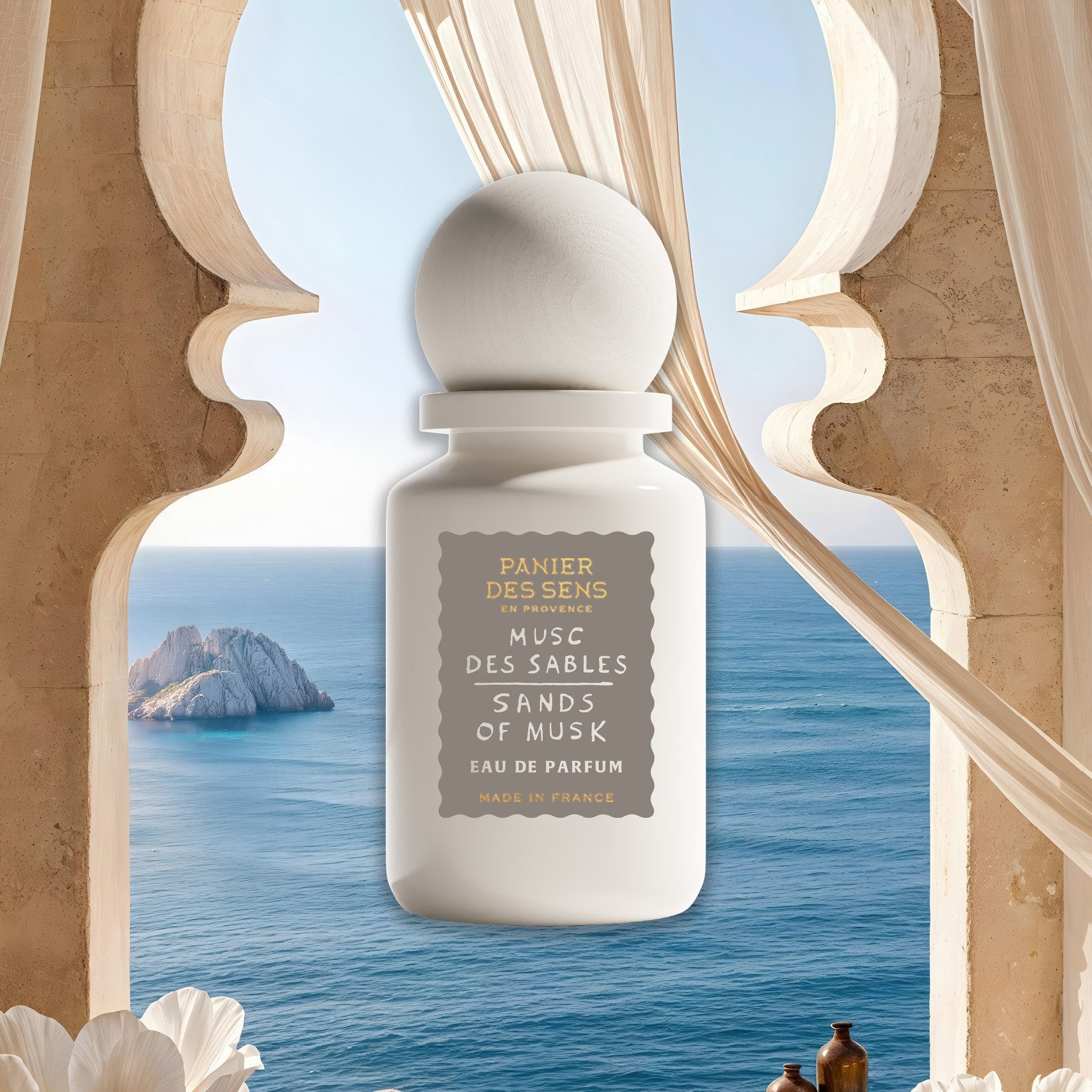 Sands of Musk perfume bottle with scenic ocean view through decorative archway