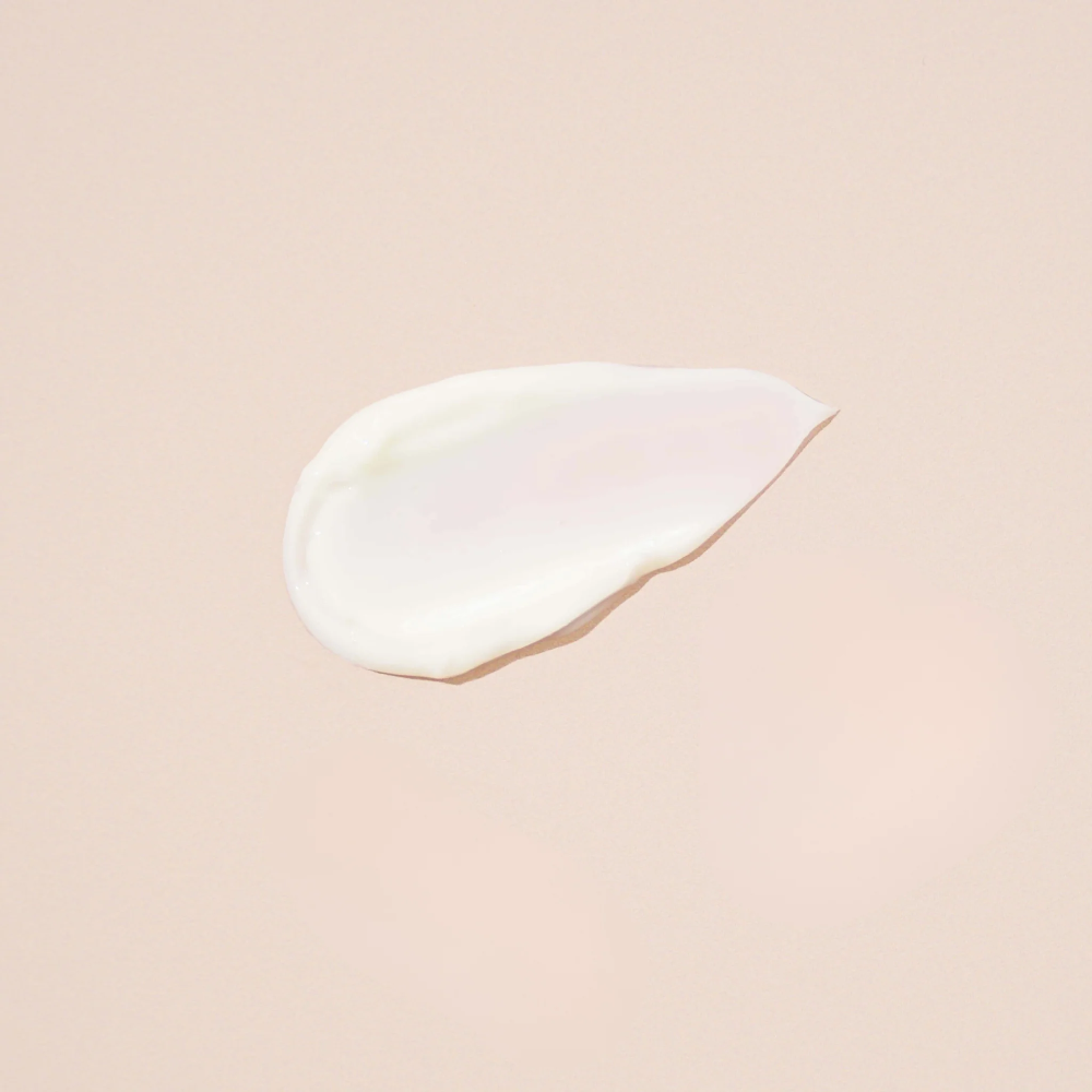 White cream droplet on a beige background