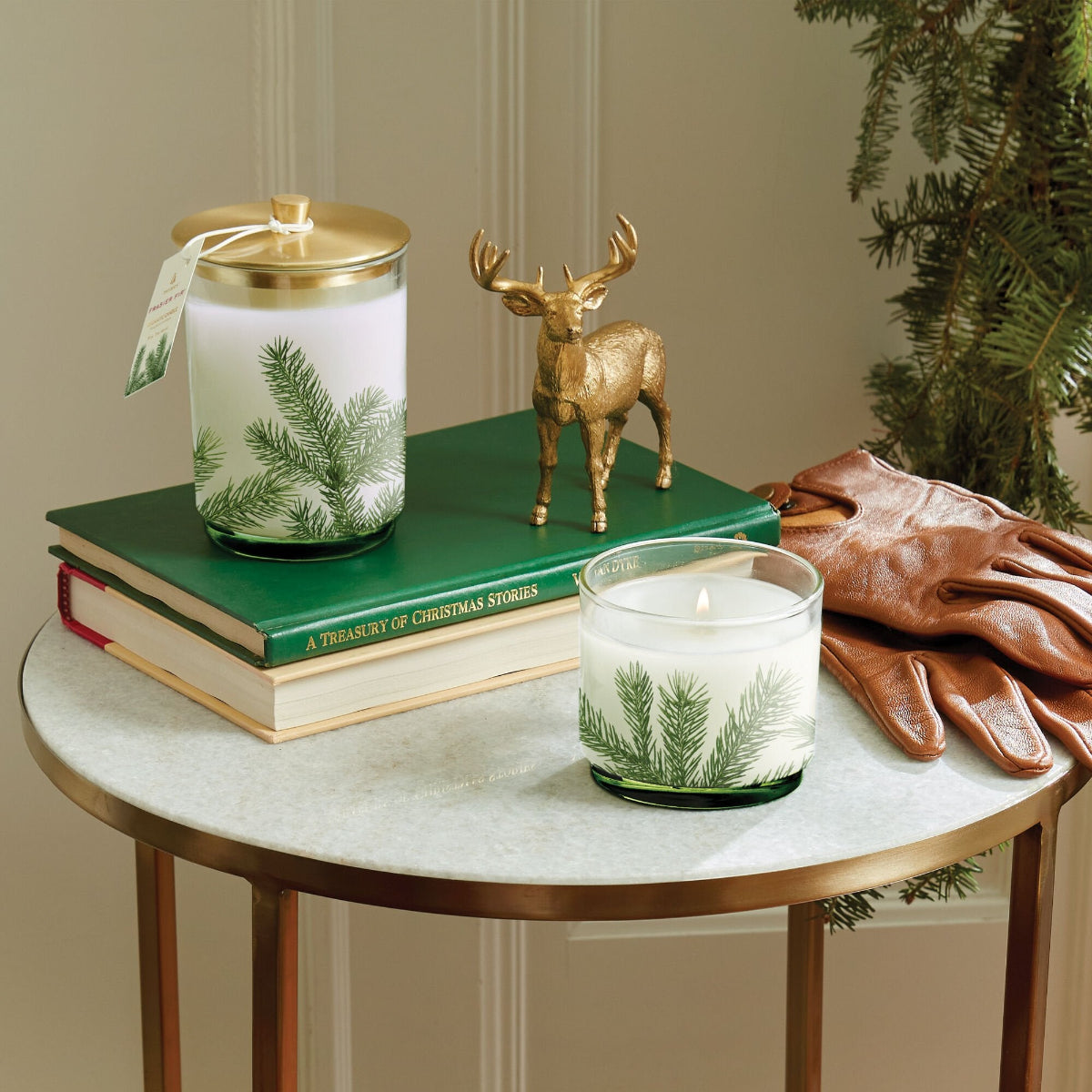 Decorative setup with candles, books, and a deer figurine on a table.