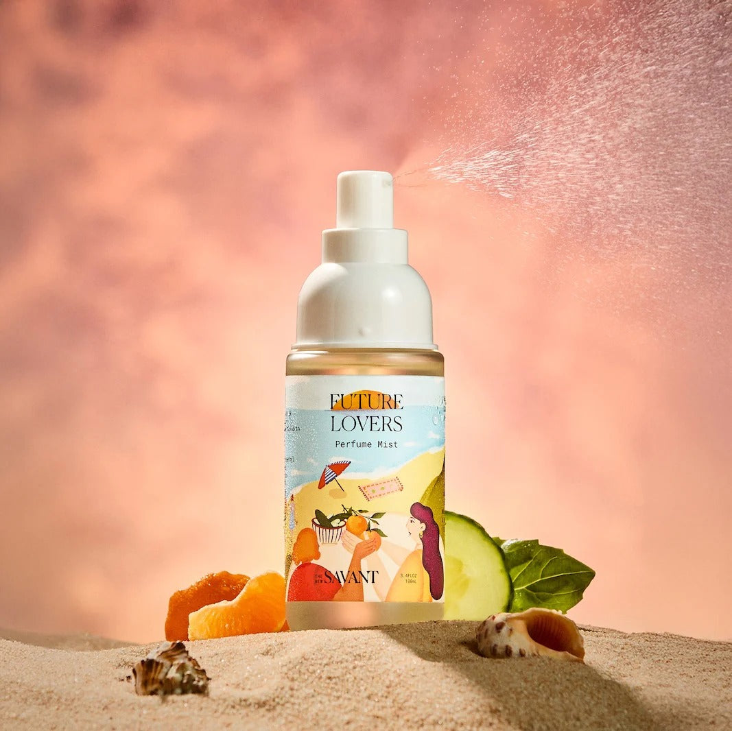 Perfume mist bottle with a colorful label on a sandy background