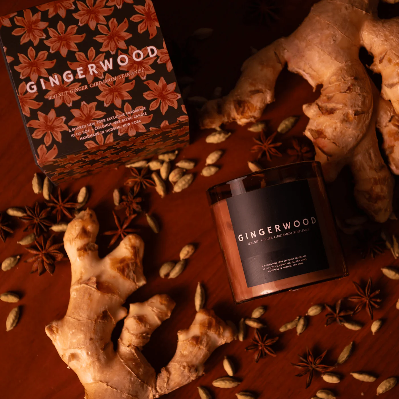 Gingerwood candle and packaging with ginger root and star anise on a wooden surface