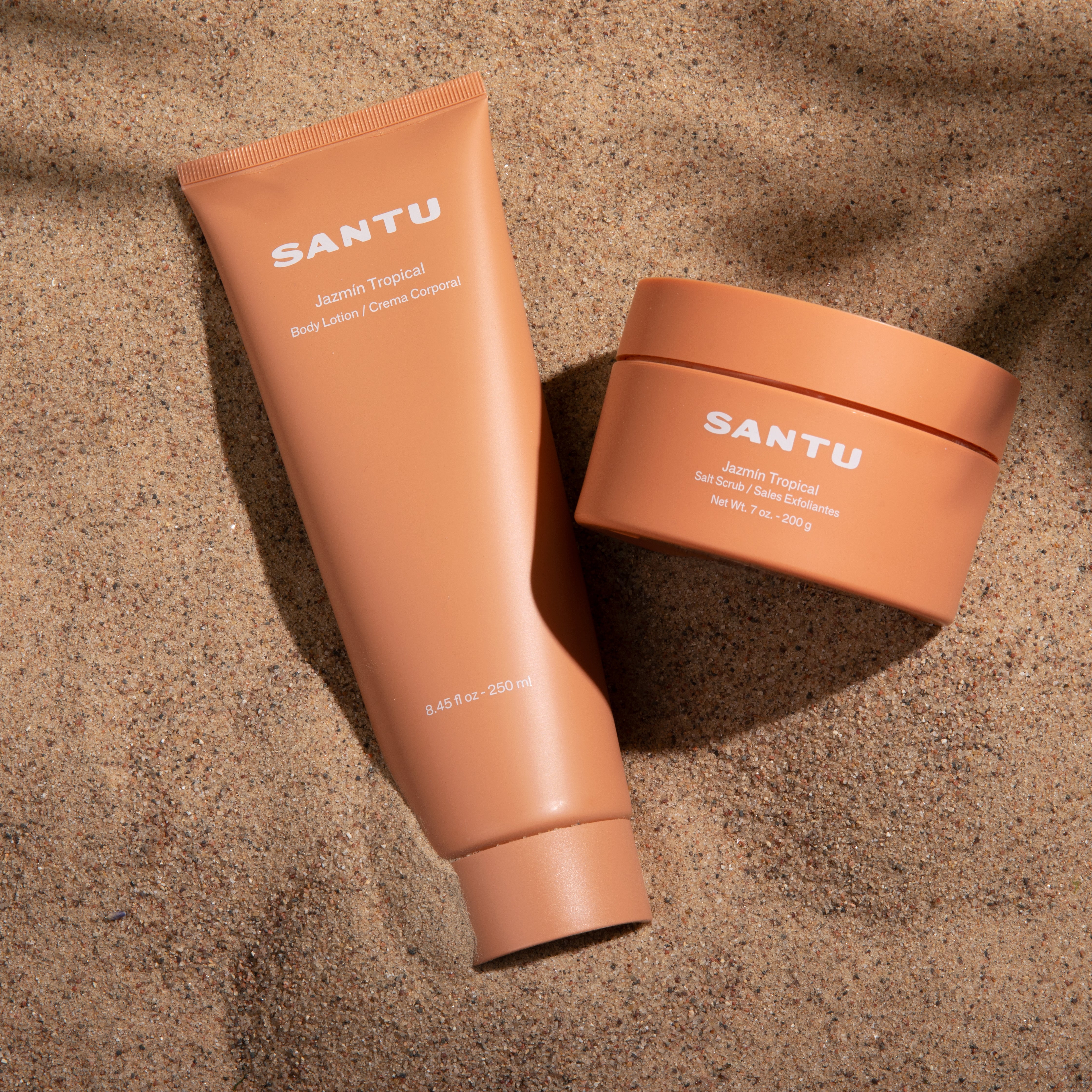 SANTU body lotion and salt scrub on a sandy background