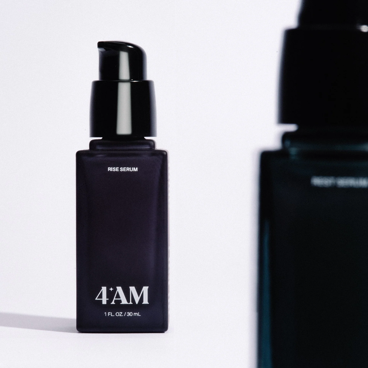 Two black skincare bottles with '4AM' branding on a white background