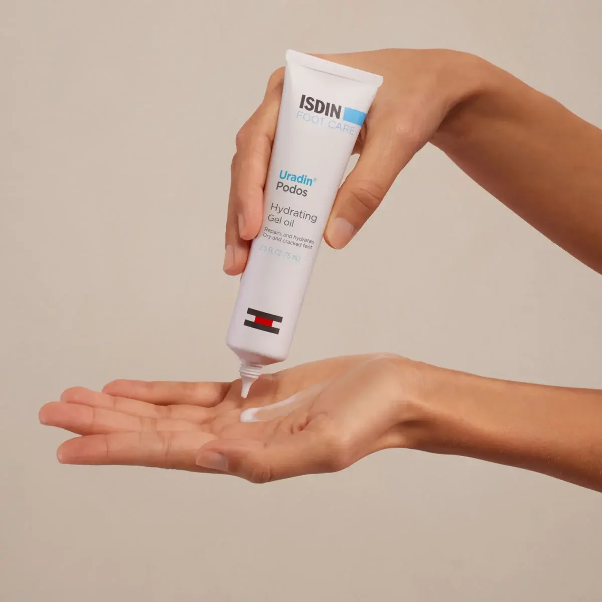 Hand applying ISDIN cream to another hand against a beige background