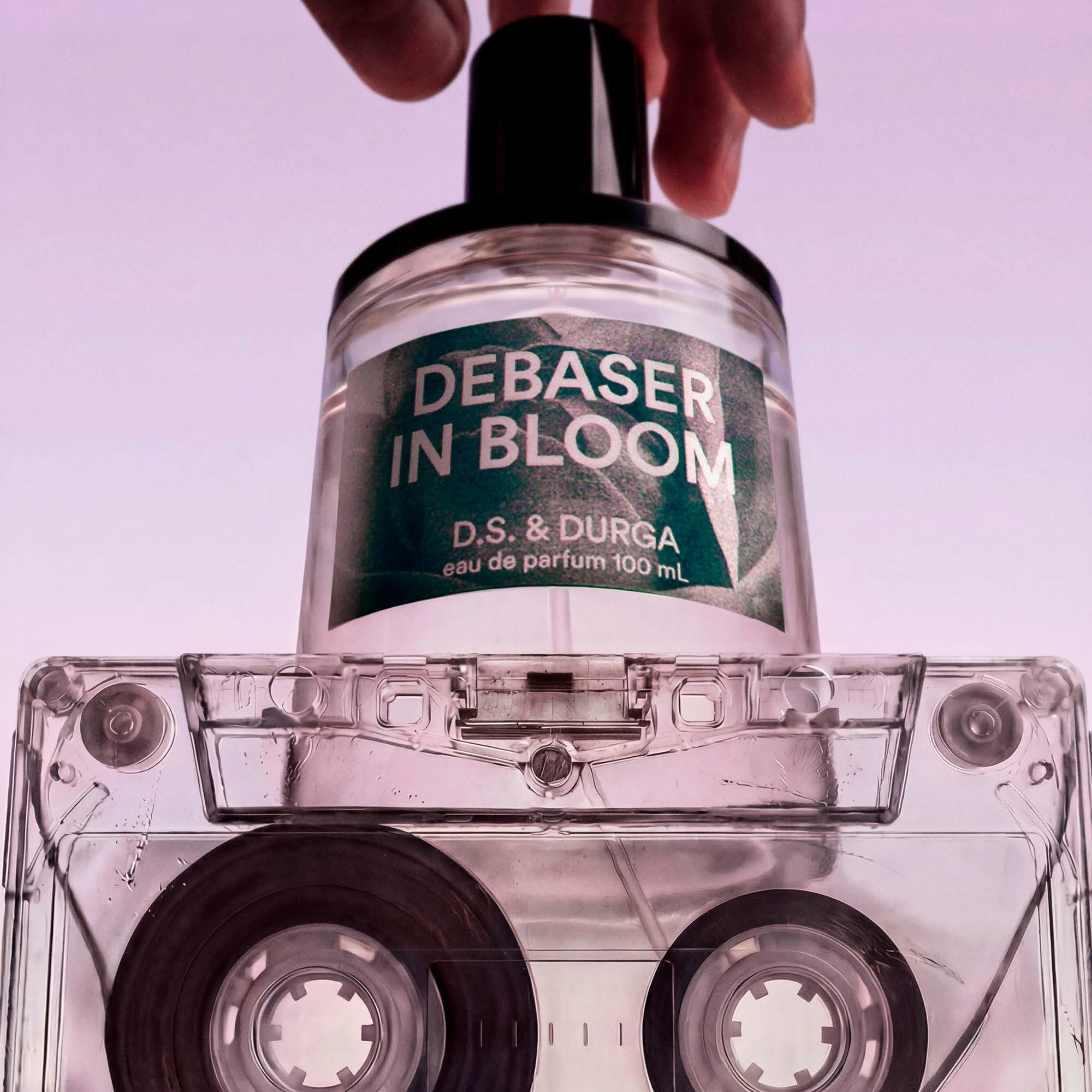 Perfume bottle labeled 'Debaser in Bloom' by D.S. & Durga on a clear cassette tape.