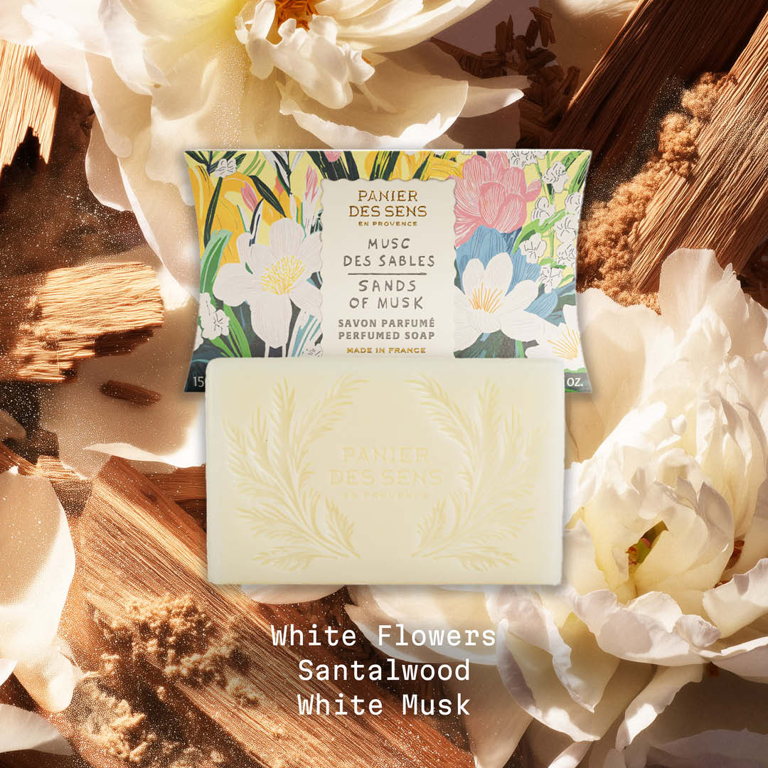 Sands of Musk Bar of soap with floral packaging on a wooden surface with flowers