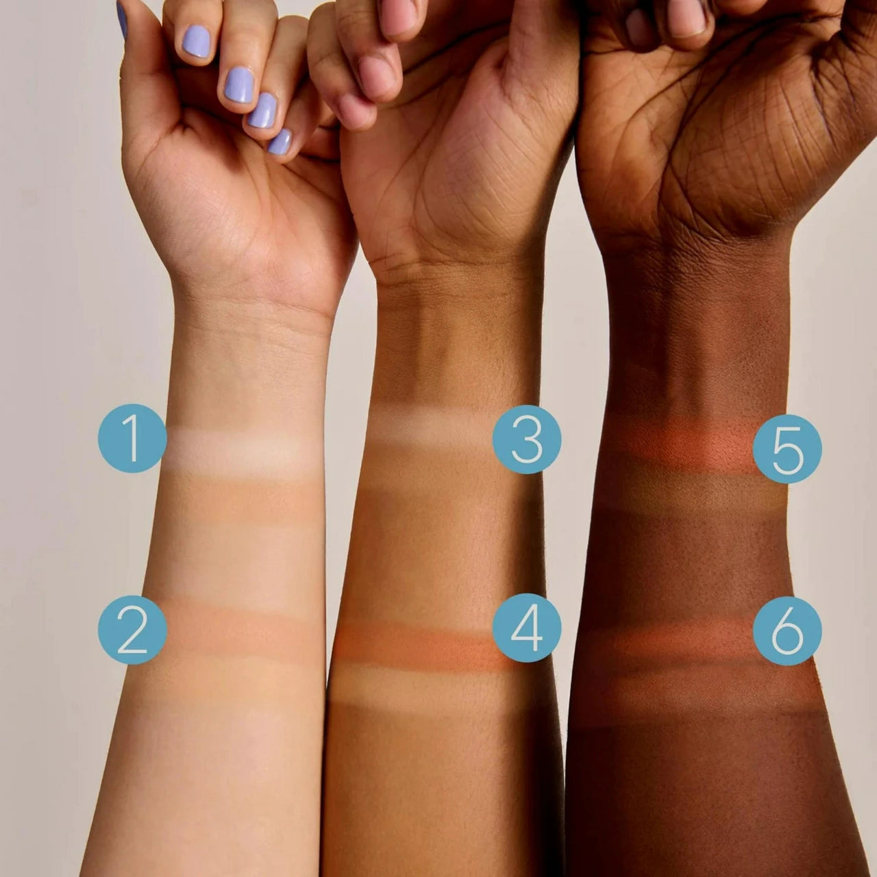 Three arms with numbered makeup swatches overlaid in blue circles, showing different skin-tone makeup shades from light to deep brown against a plain light background.
