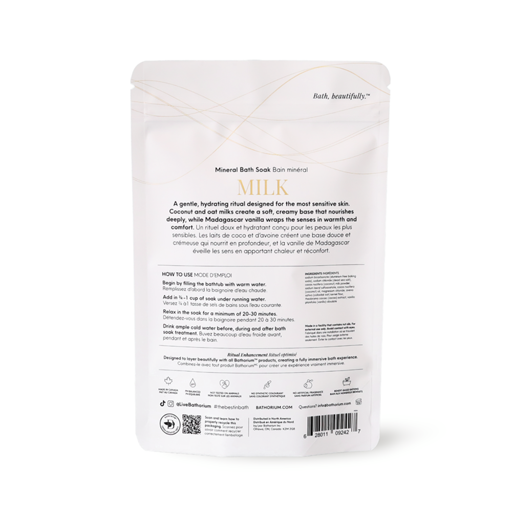 A white stand-up pouch of Bath & Beauty 'Milk' Mineral Bath Soak with French and English instructions on the back, photographed against a seamless white background.