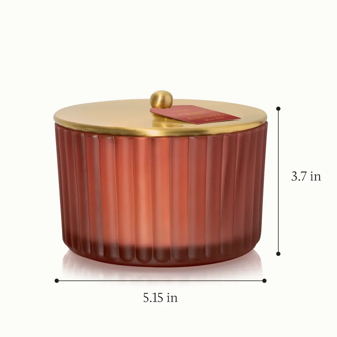 A ribbed glass lidded container in a warm red-orange gradient with a metallic gold lid and knob, shown on a white background with dimension lines indicating 5.15 in width and 3.