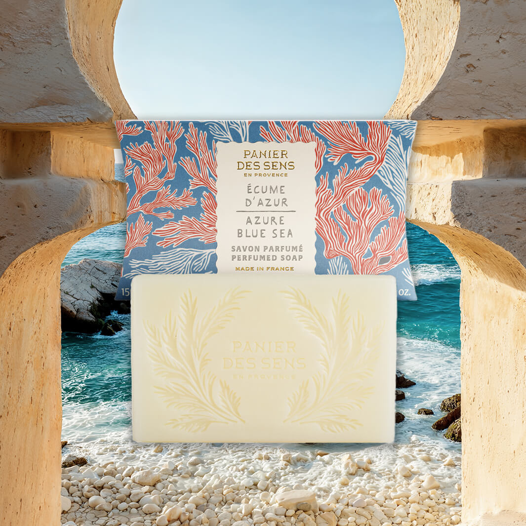 Azure Blue Sea Bar of soap with packaging featuring ocean design on a pebble beach with ocean view