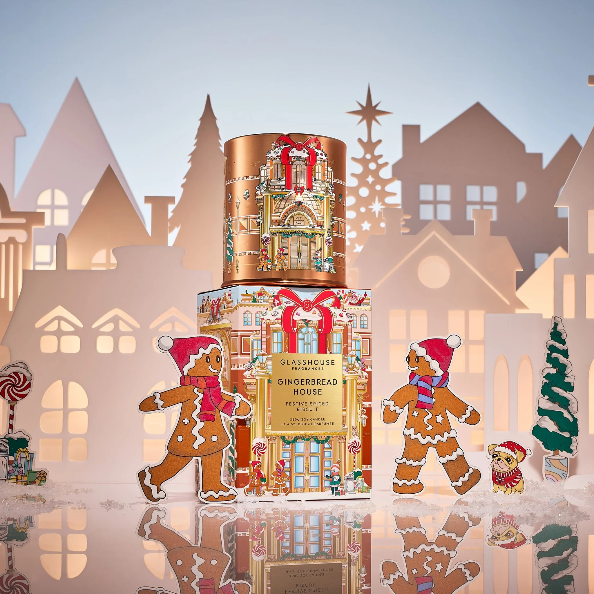 Decorative Christmas packaging with gingerbread men and a building design against a festive village backdrop.