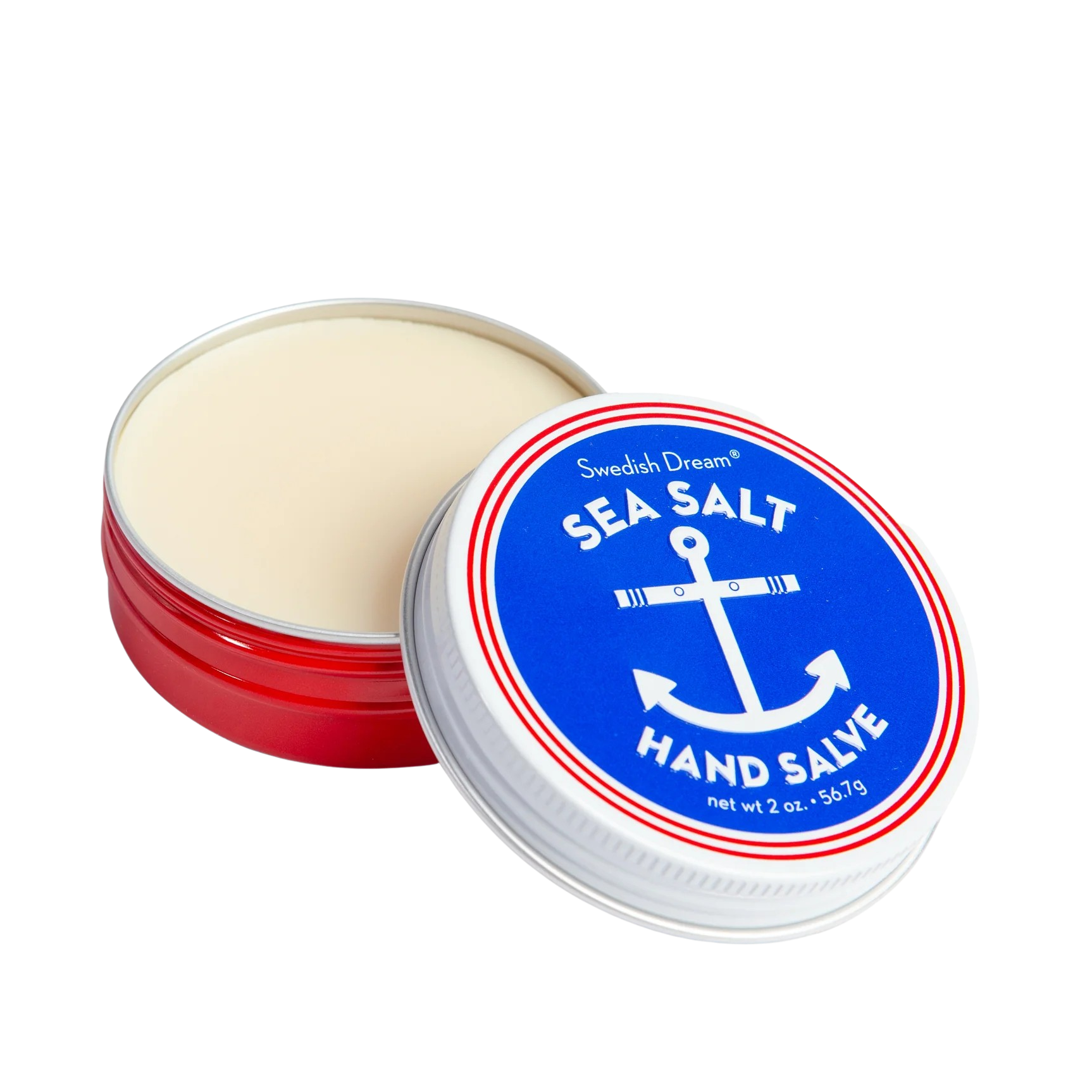 An open round metal tin of Sea Salt Hand Salve by Smoked Dreams, showing the off-white salve inside, with the white lid leaning against it. The lid features a prominent blue label with a white anchor and red border.
