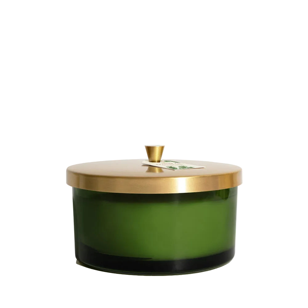 Green candle with a gold lid on a white background
