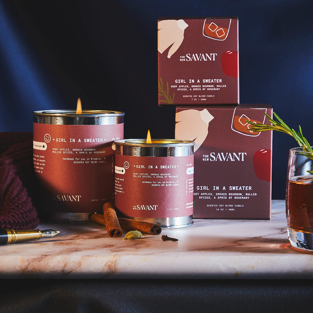 Savant candles and packaging on a table with a dark background