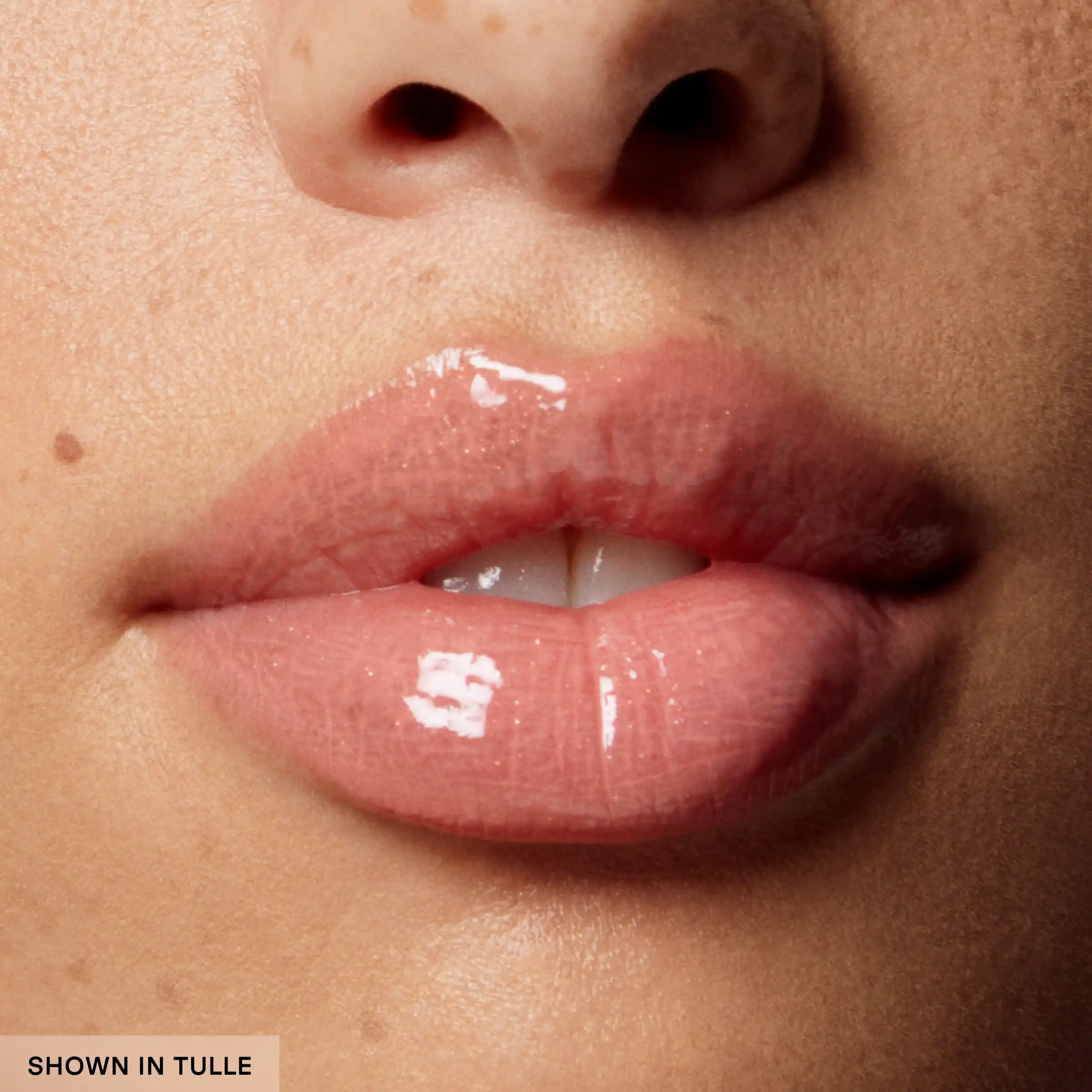 Close-up of glossy pink lips with a neutral background