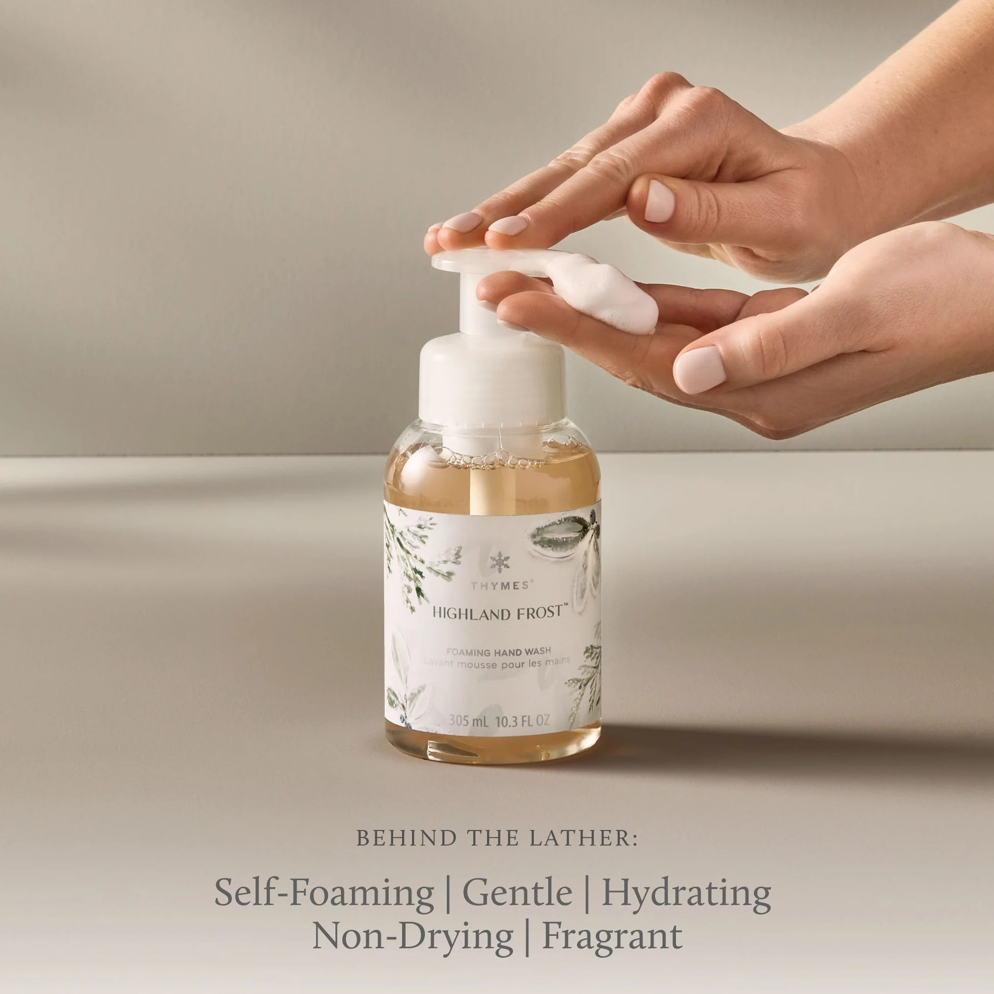 Hand holding a bottle of Highland Frost hand wash with a neutral background