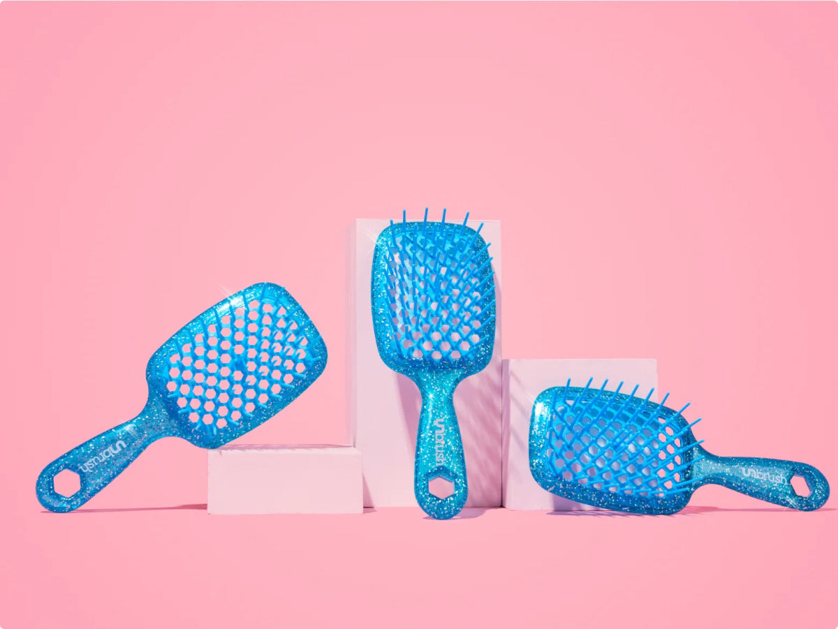 Set of blue hairbrushes on a pink background